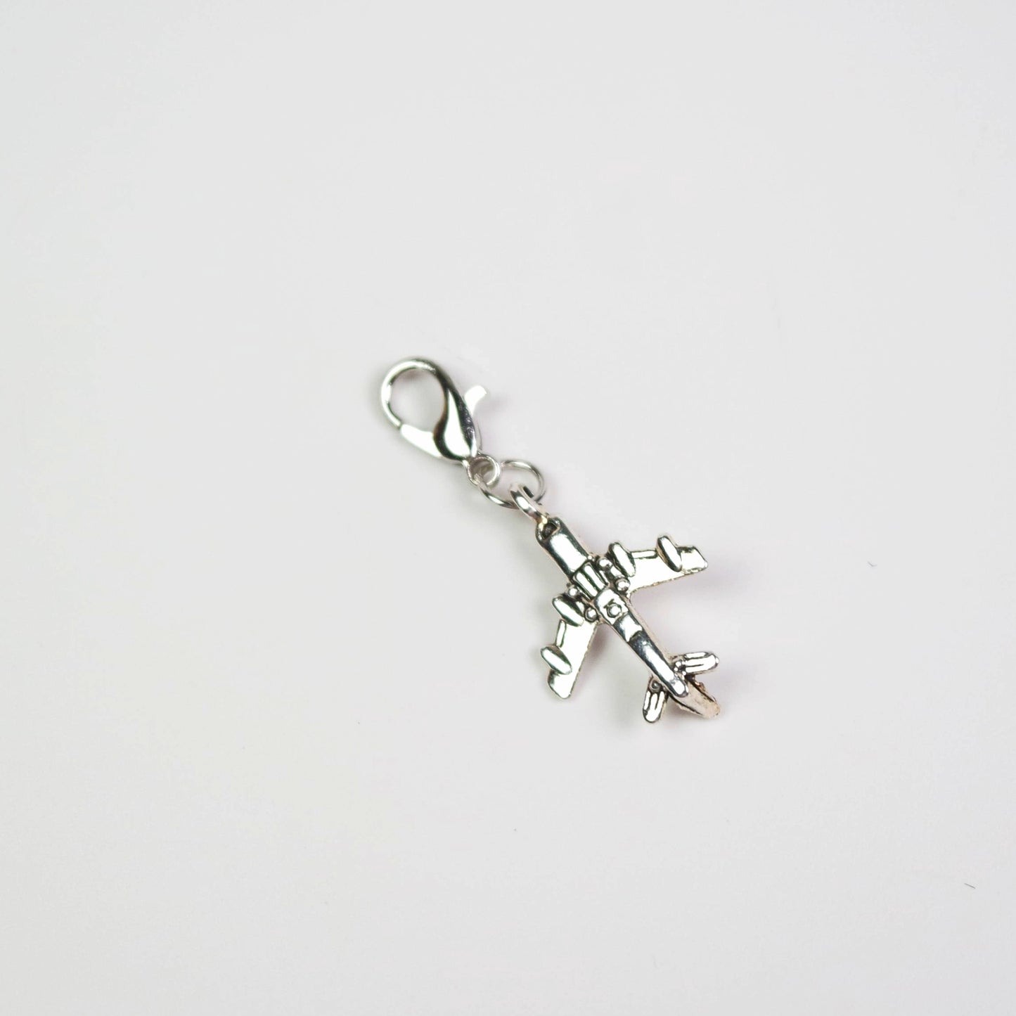 Silver airplane charm on a white background