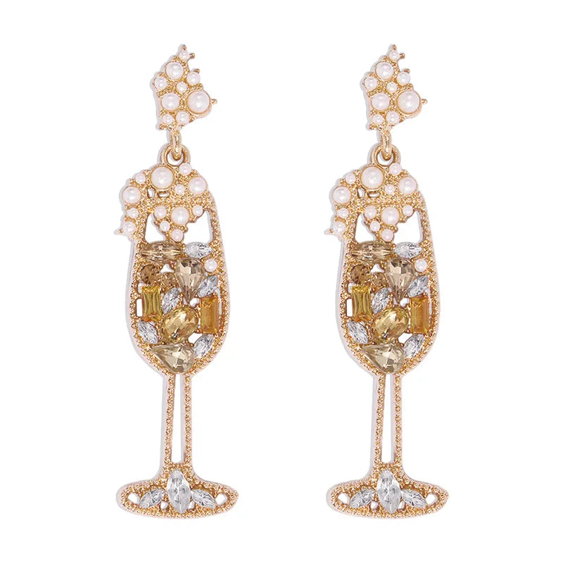 A pair of gold-tone rhinestone dangle earrings designed to resemble champagne glasses, with gold and clear rhinestones and pearl beaded details.