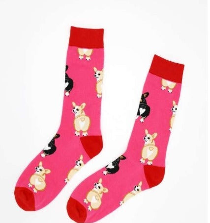 A pair of hot pink crew socks with black and white corgi dog patterns and red heels and toes.