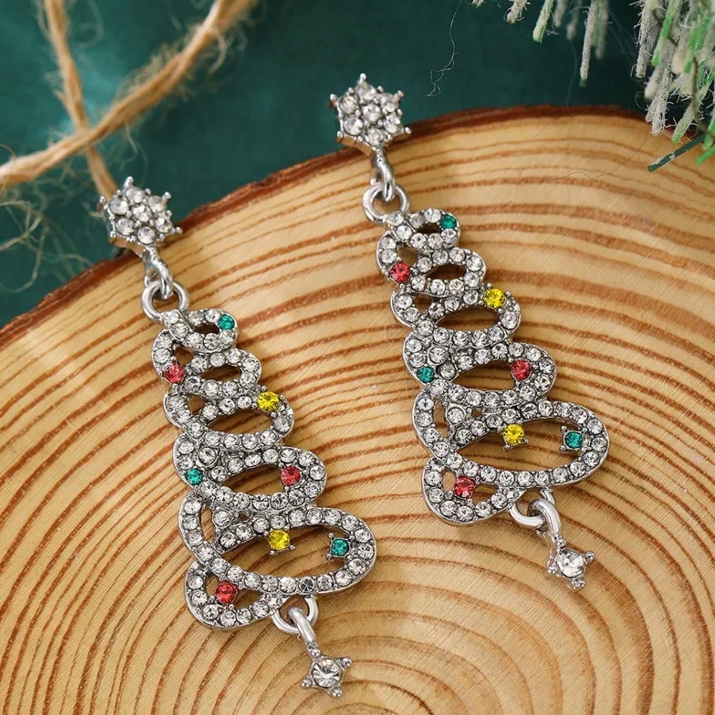 Decorative earrings with colorful gemstones on a wooden surface