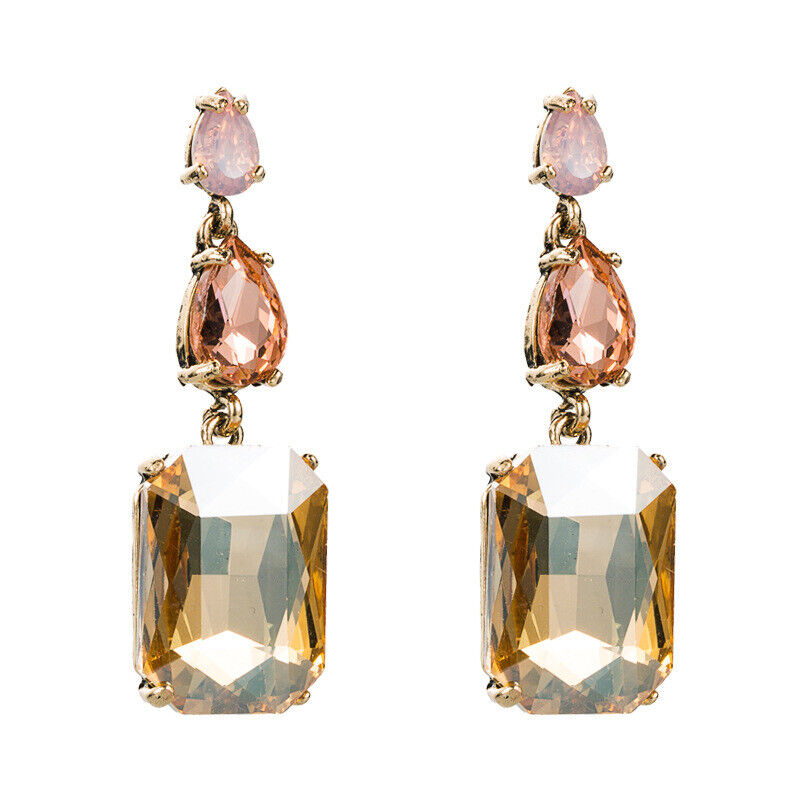 A pair of gold-tone dangle earrings with pink and champagne colored gemstones.