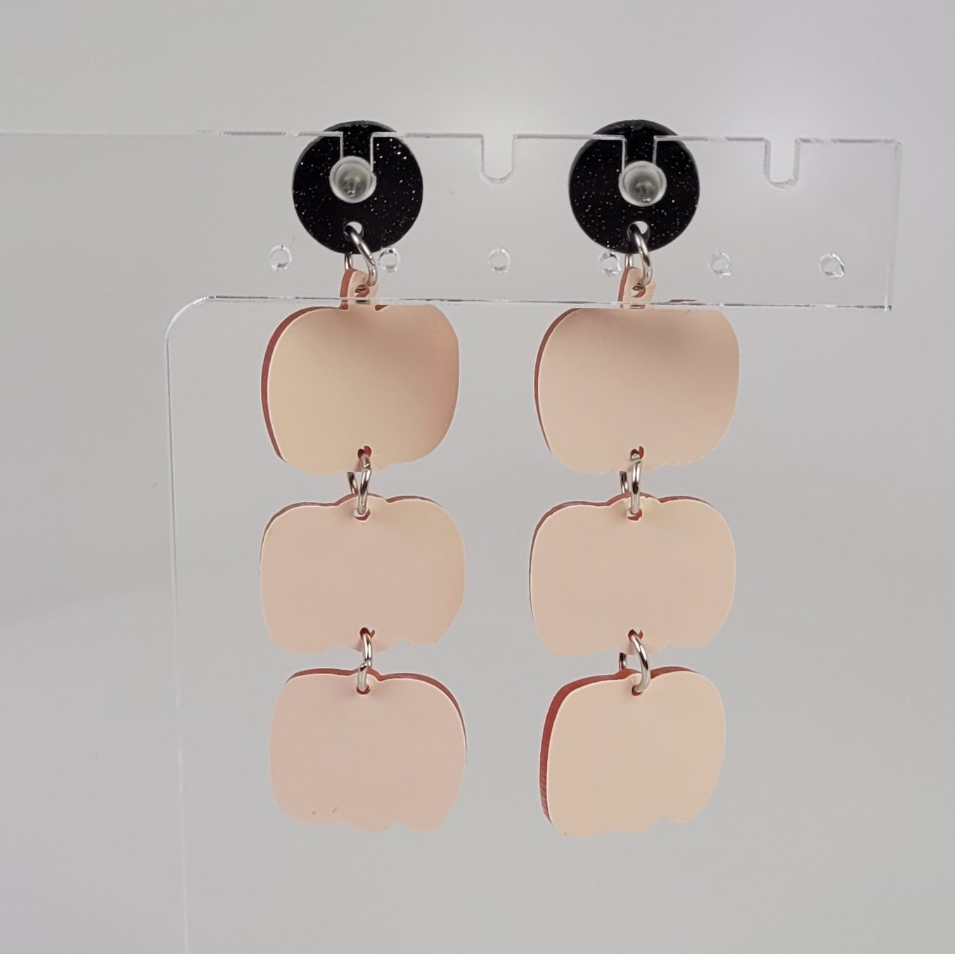 Backside View of Halloween-themed earrings with jack-o'-lantern faces on a white background