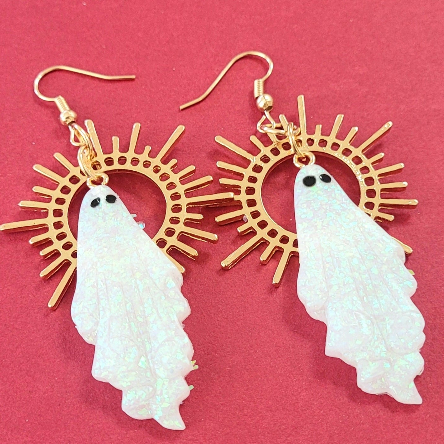 Earrings with ghost designs on a pink background