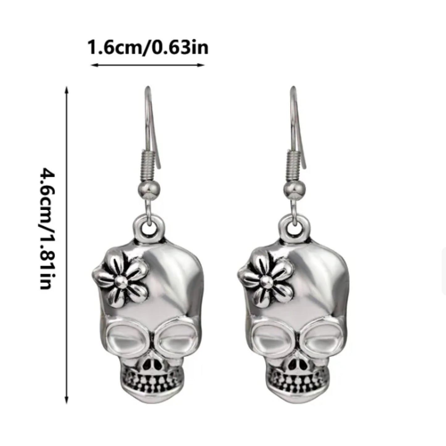 Silver skull-shaped earrings with floral details and measurements on a white background