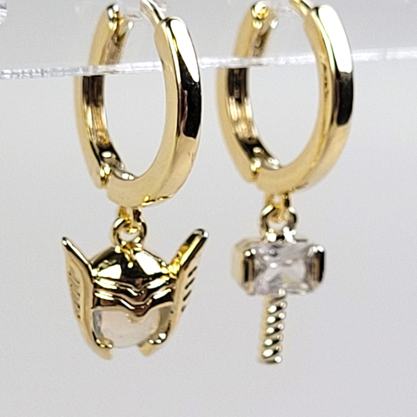 Gold hoop earrings with cat and paw print charms on a white background