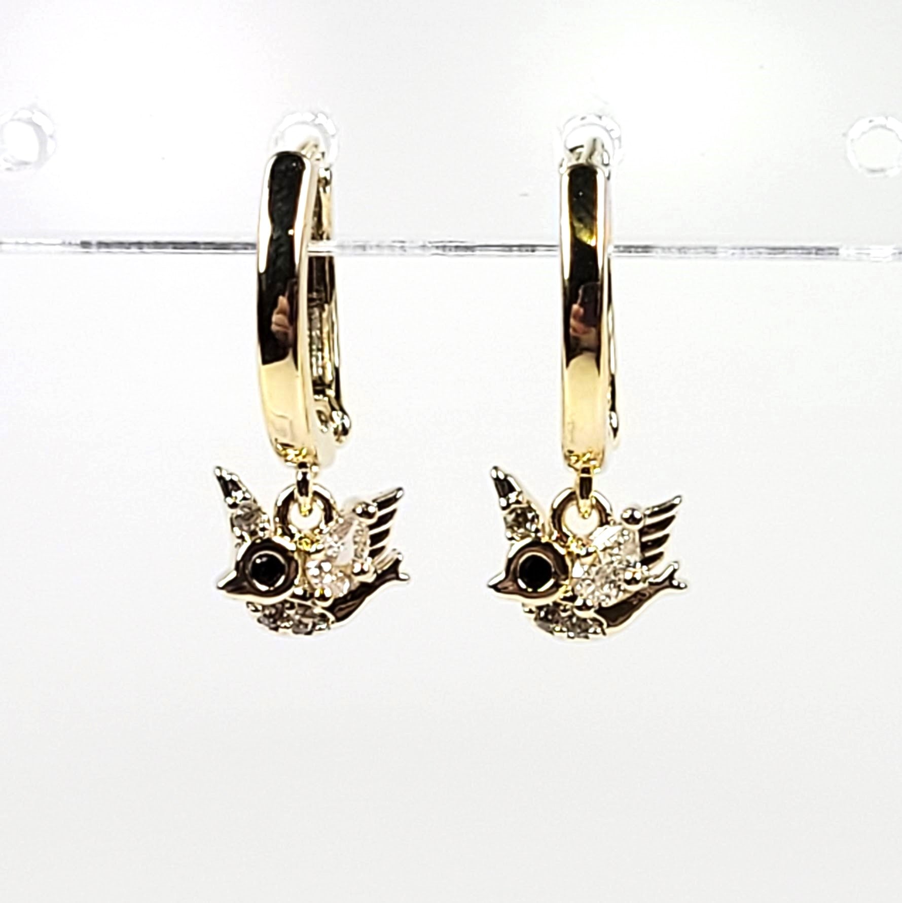 Gold hoop earrings with bird charms on a white background