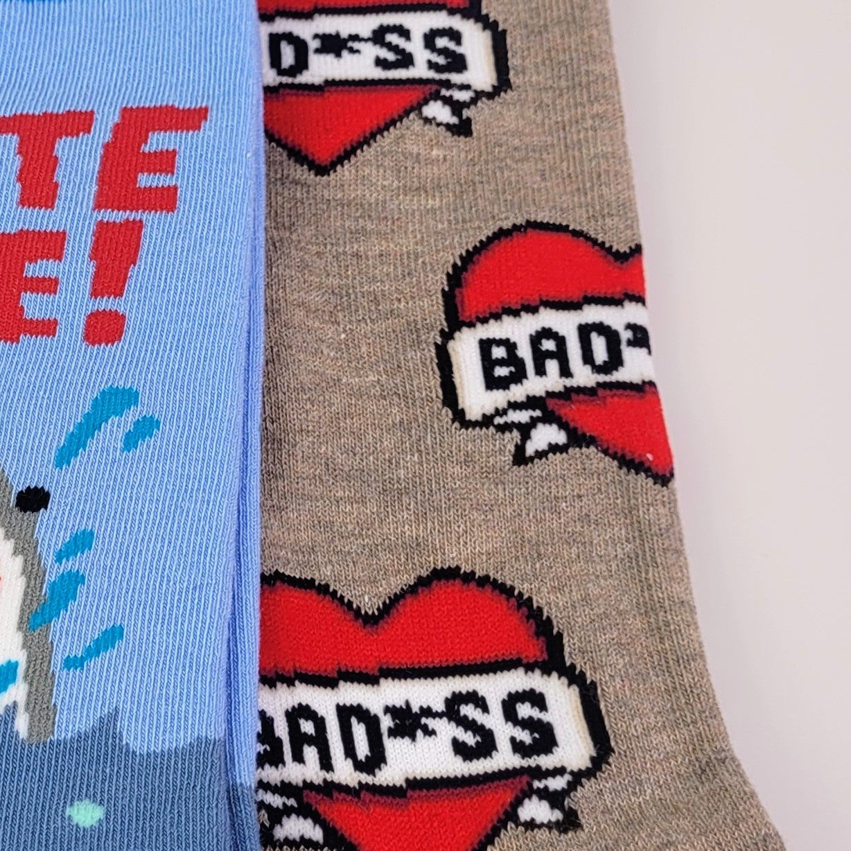 Two socks with graphic designs and text on a white background