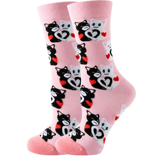 Pink socks with black cat and heart designs on a white background