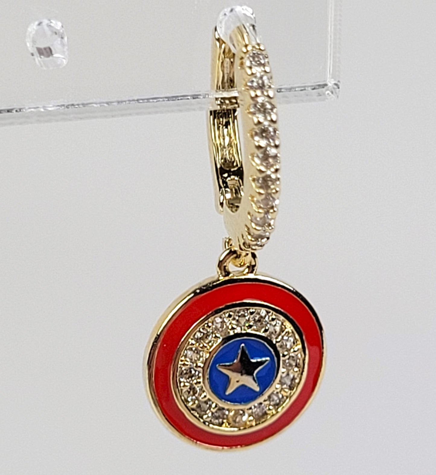 Gold pendant with red and blue circular design on a clear background