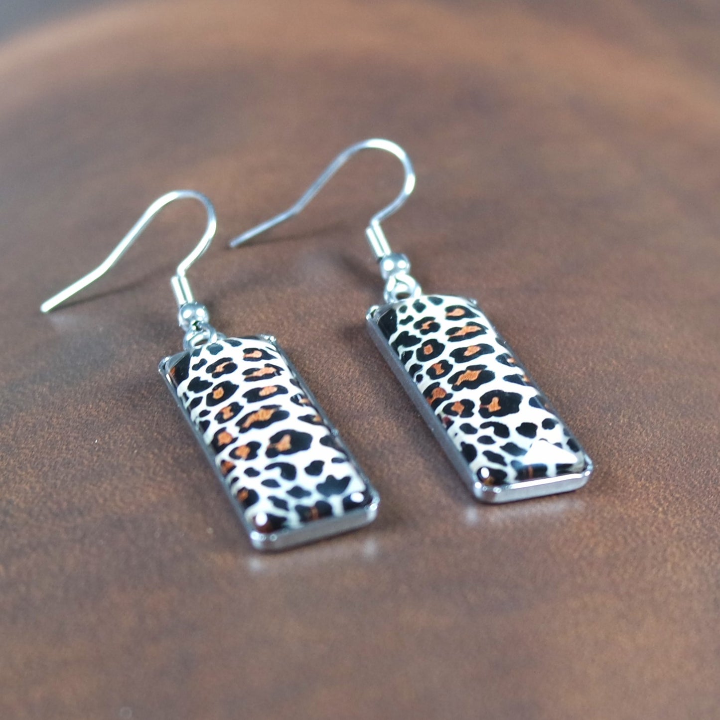 Leopard print earrings on a wooden surface