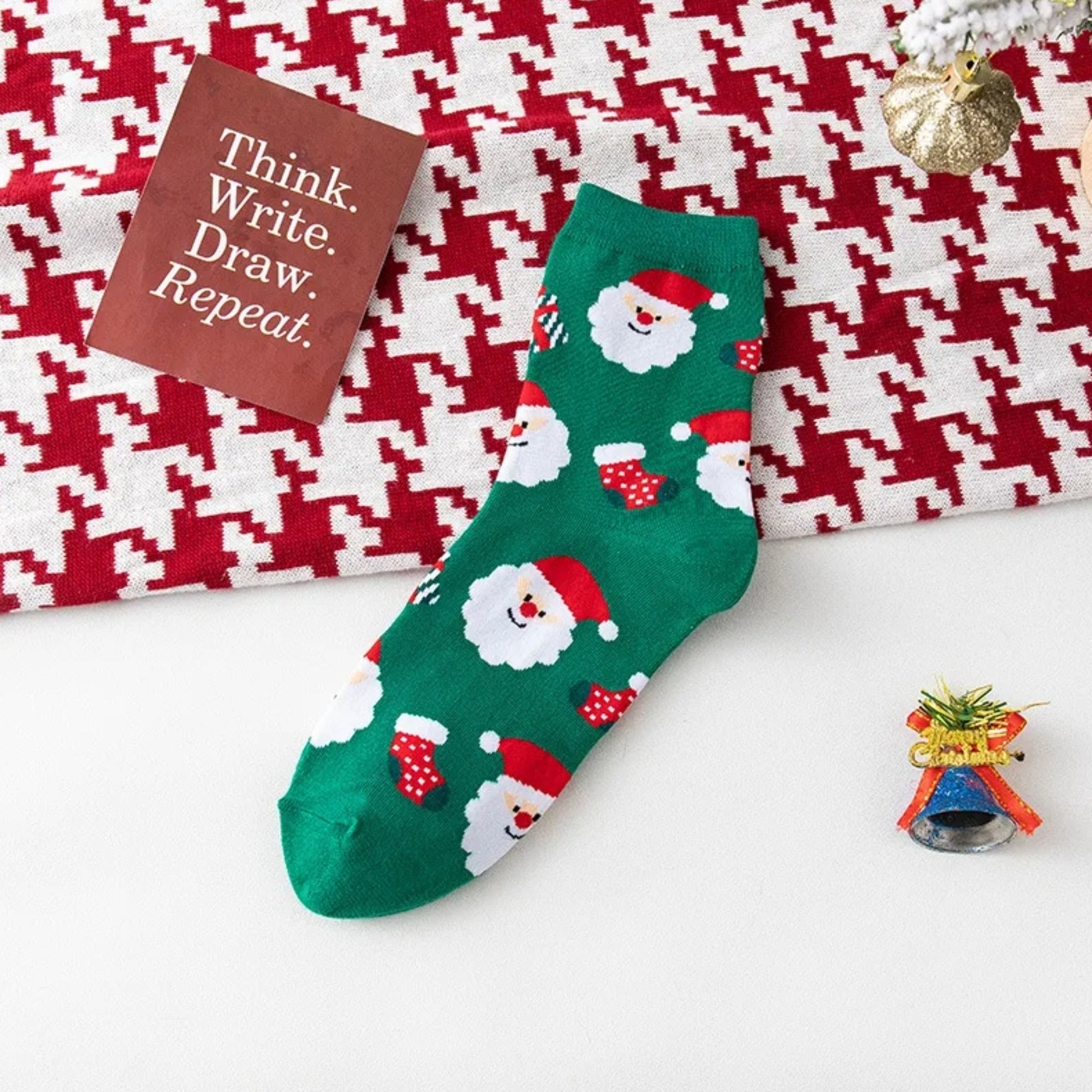 Green Christmas-themed sock with Santa Claus design on a patterned surface
