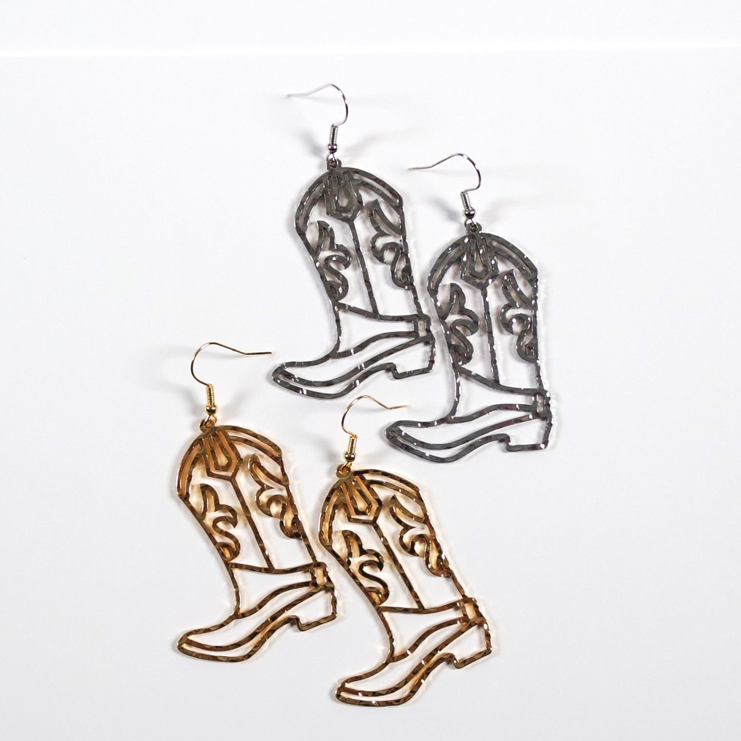 Cowboy boot earrings in gold and silver on a white background