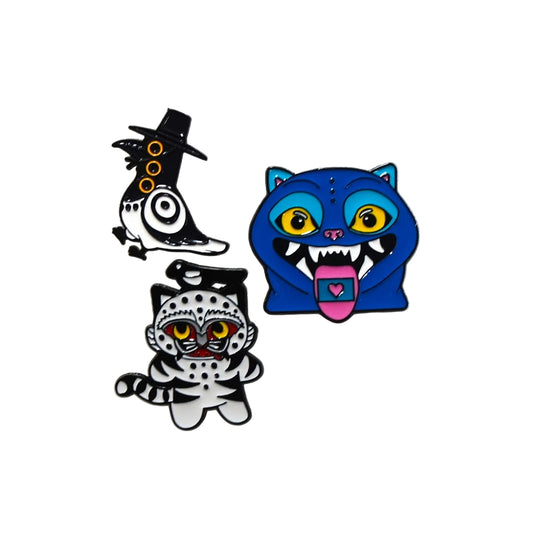 Three colorful cat-shaped pins on a textured white background