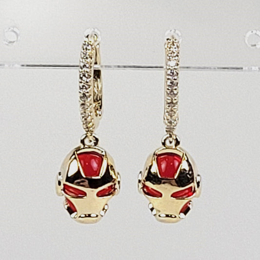 Gold and red earrings on a light gray background