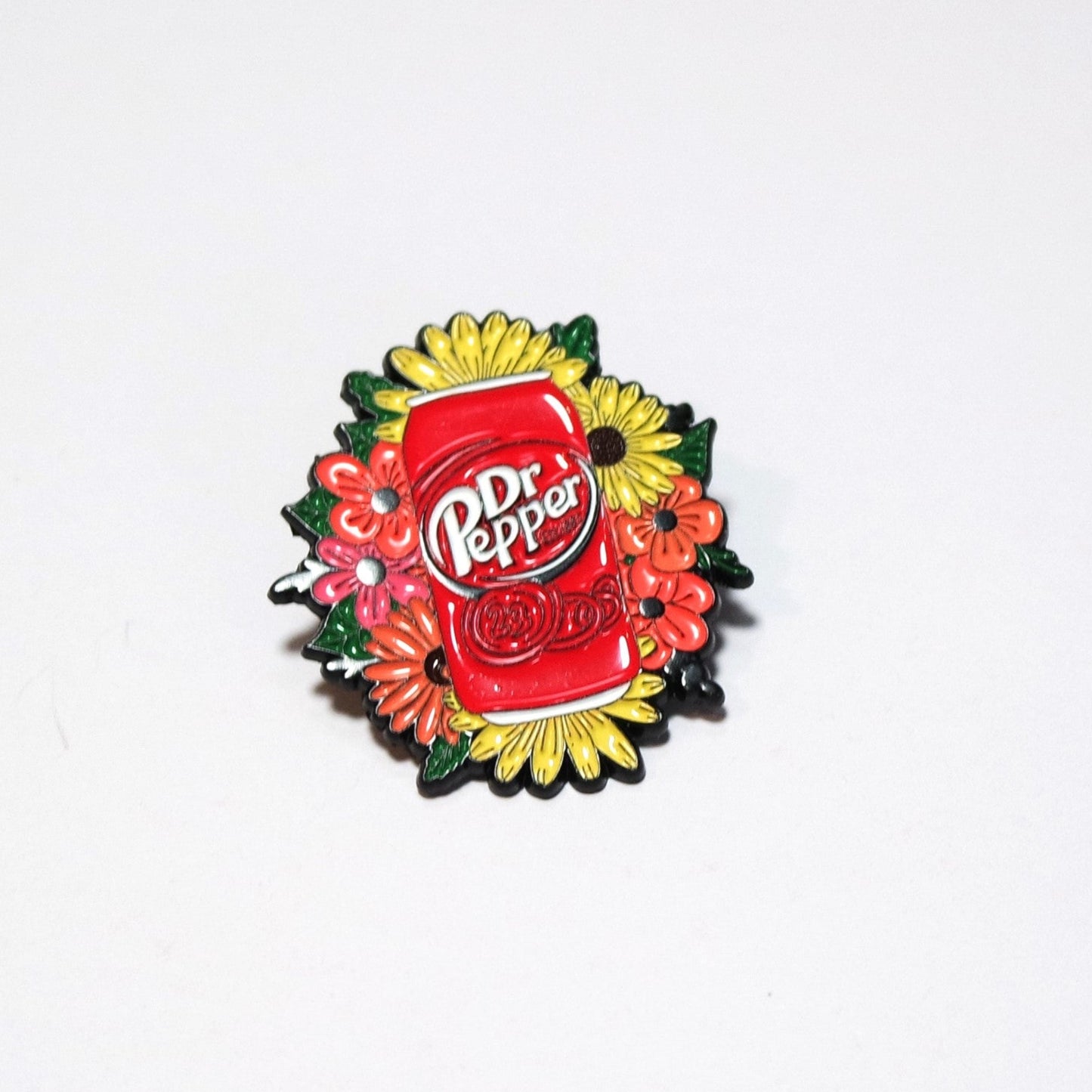 Dr Pepper logo on a decorative pin with flowers on a white background
