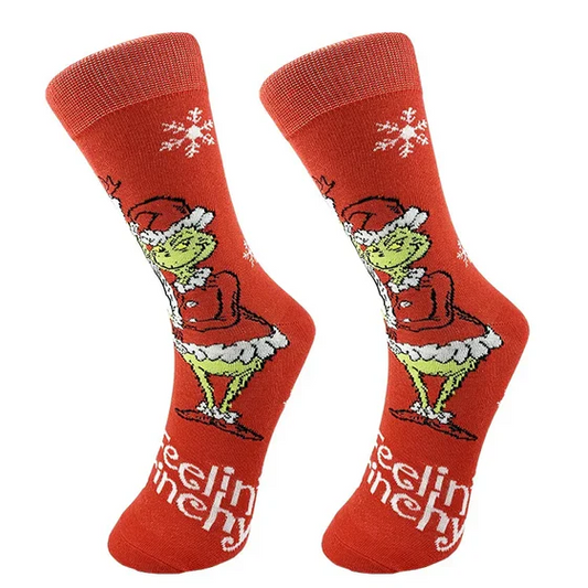 Red socks with a character design and 'feeling grinchy' text on a white background