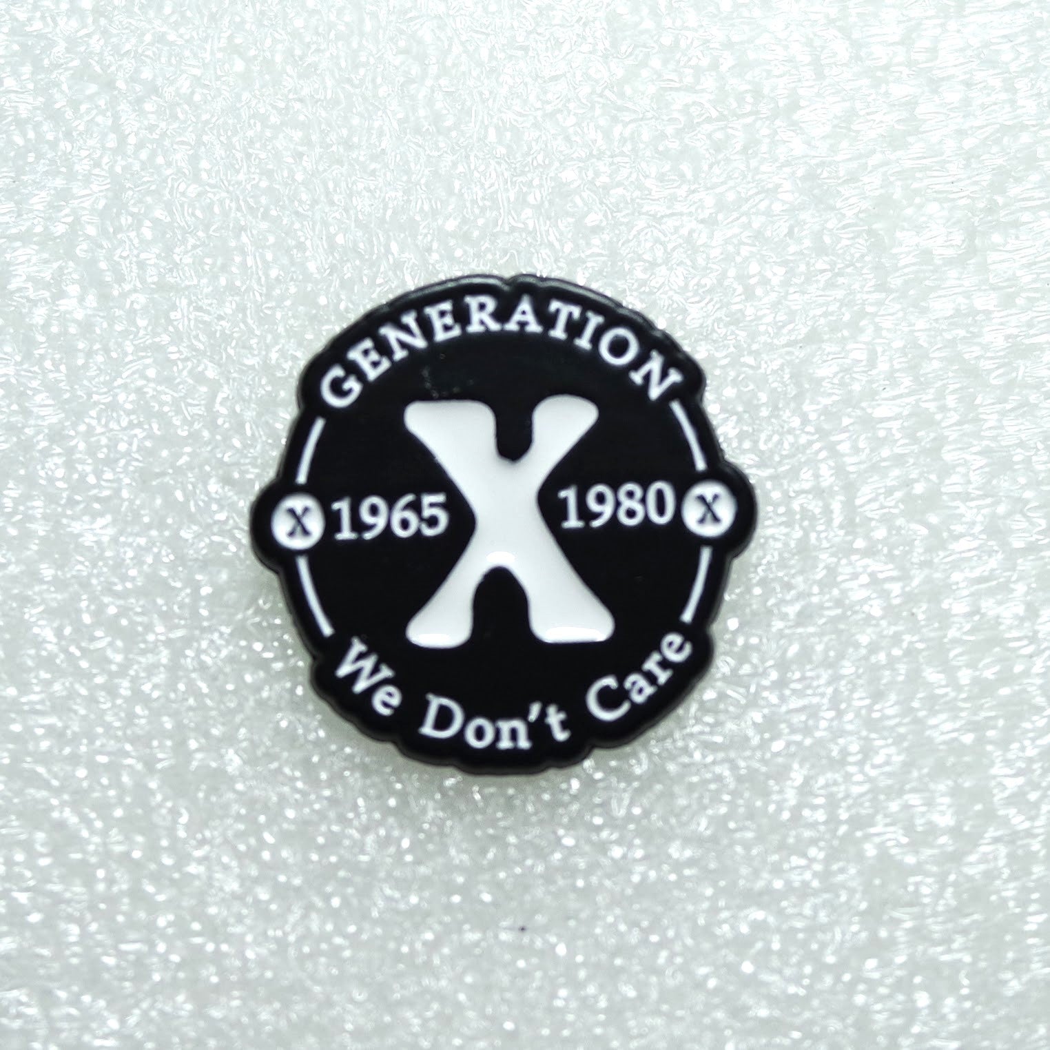 Round black badge with 'Generation X 1965 1980 We Don't Care' text on a textured white background