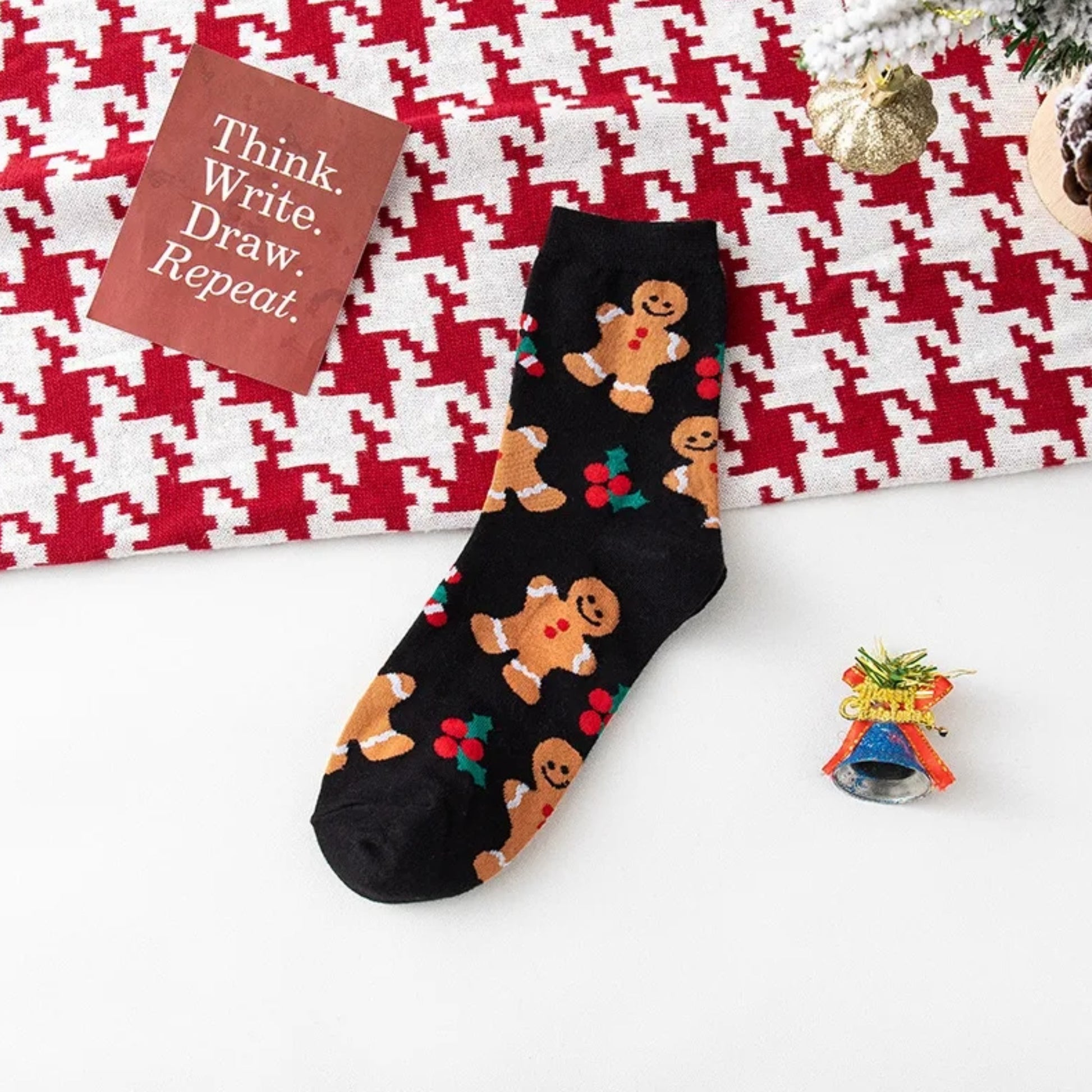 Black sock with gingerbread men pattern on a red and white checkered background
