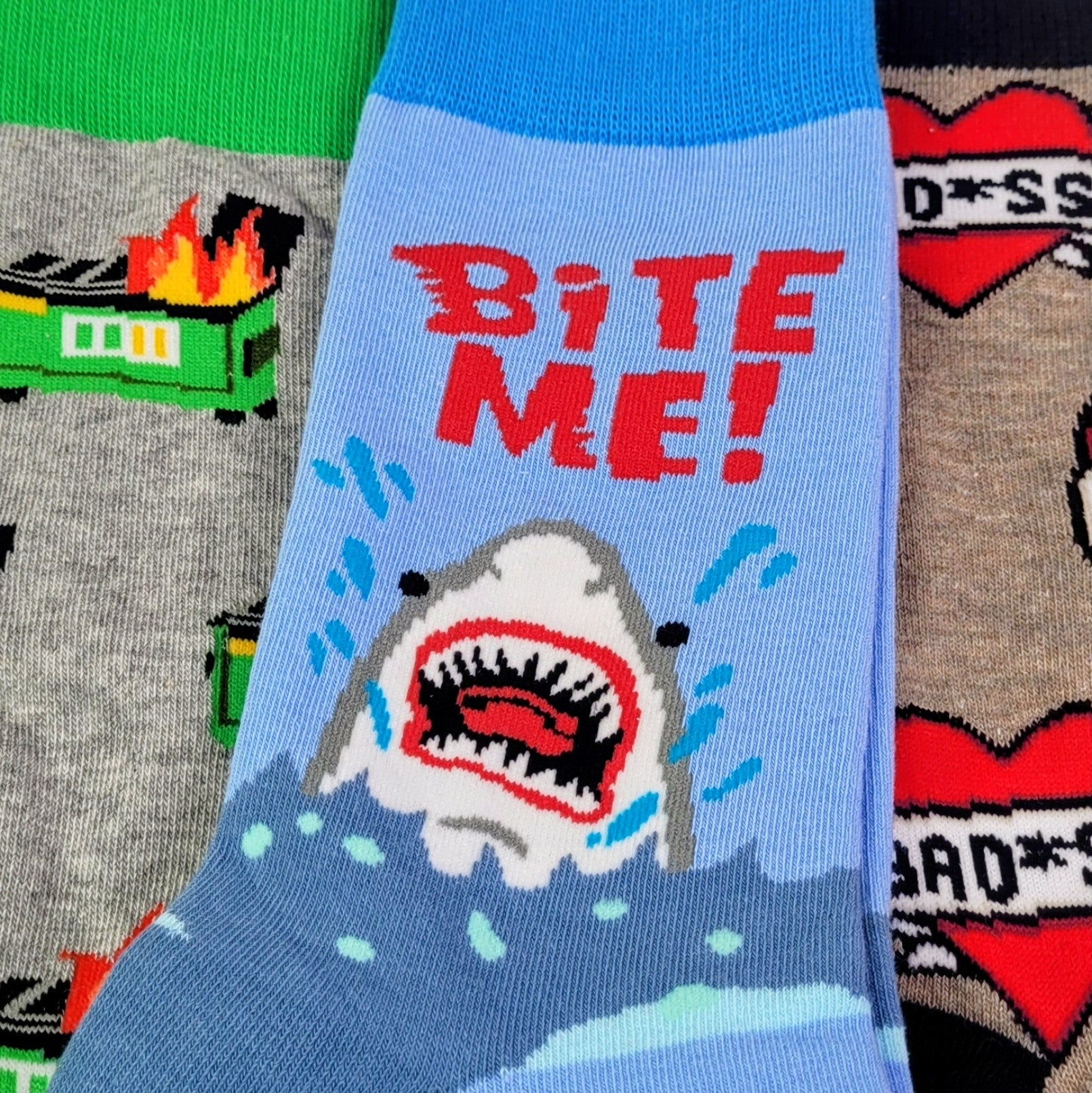 Collection of socks with various designs including a shark graphic and text.