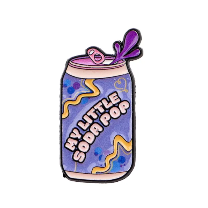 Enamel pin of a can labeled 'My Little Soda Pop' on a white background