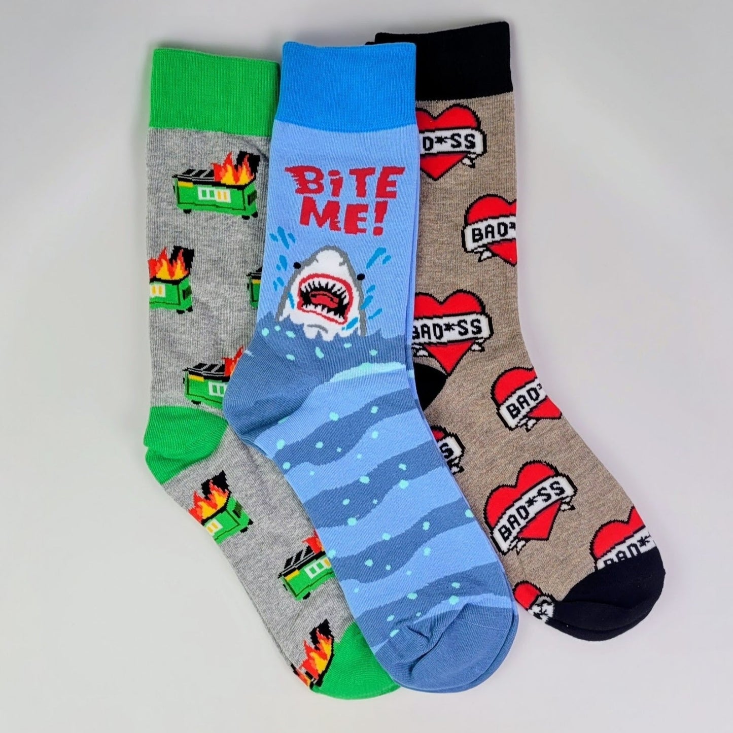 Three pairs of colorful socks with different designs on a light gray background