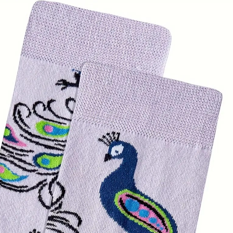 Two socks with peacock designs on a white background