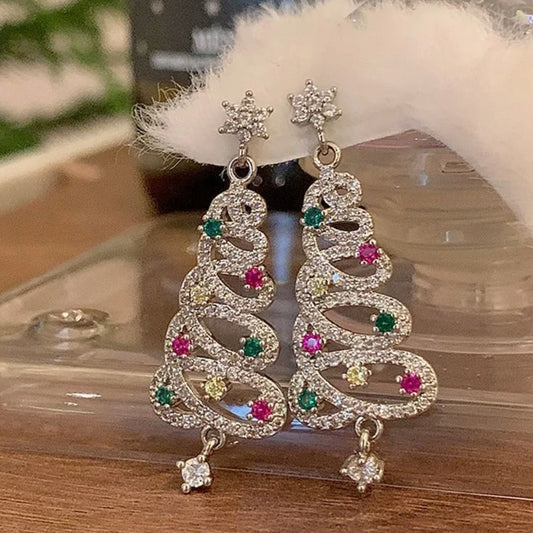 Decorative earrings with gemstones on a reflective surface