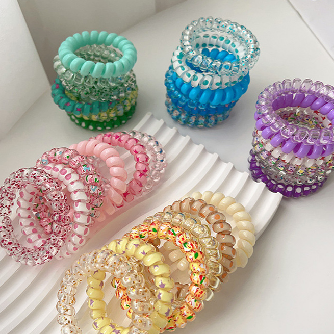 Set of colorful beaded hair ties on a white comb
