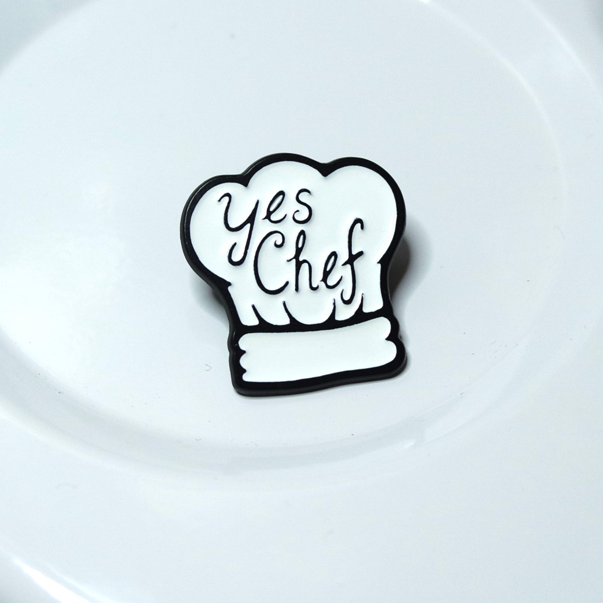 Black chef's hat with 'Yes Chef' text on a white plate