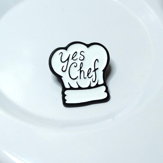 Black chef's hat with 'Yes Chef' text on a white plate