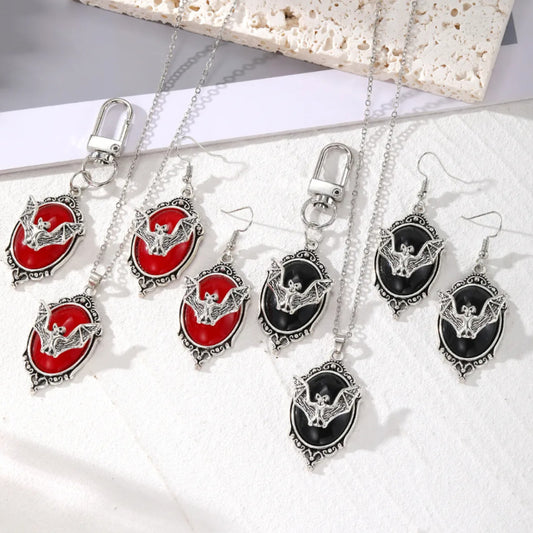 Jewelry set with bat designs on red and black stones, including necklaces and earrings.