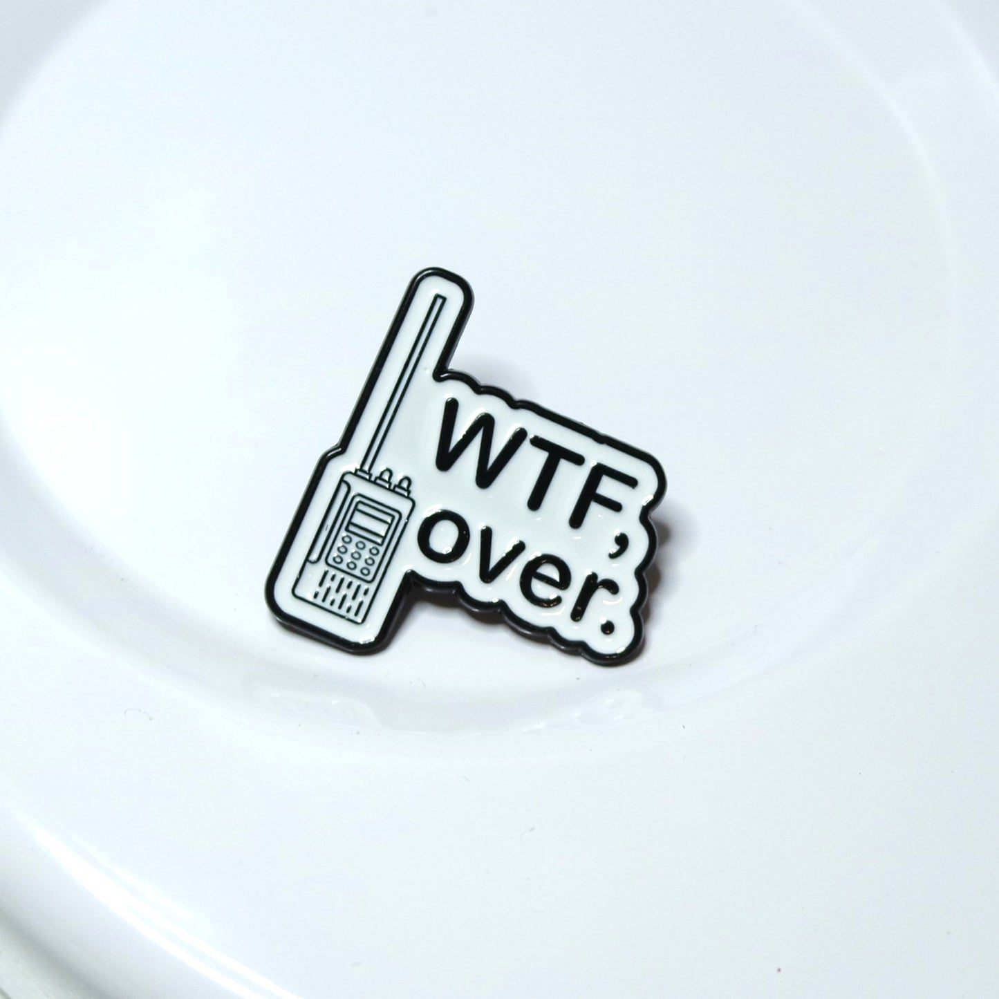 Enamel Pin with a walkie-talkie graphic and 'WTF, over.' text on a white background