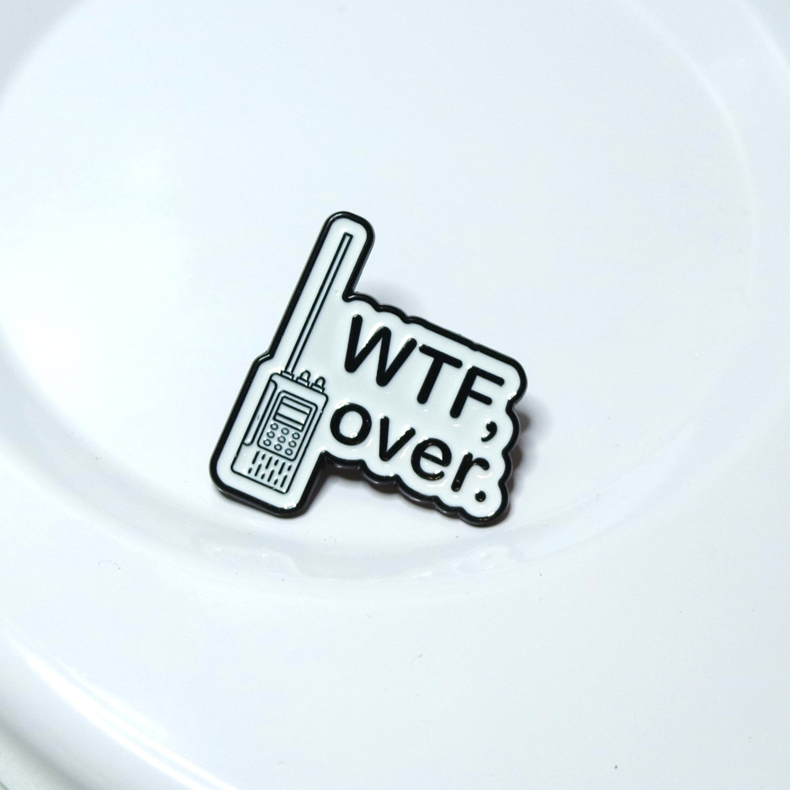 Enamel Pin with a walkie-talkie graphic and 'WTF, over.' text on a white background