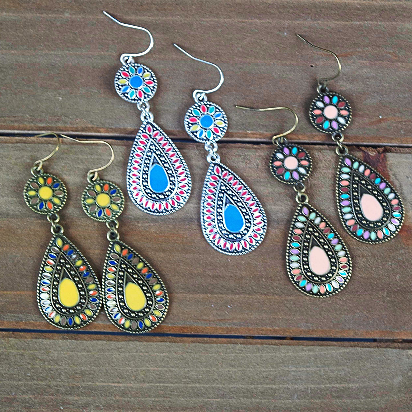 Trio of western style dangle earrings on wooden background