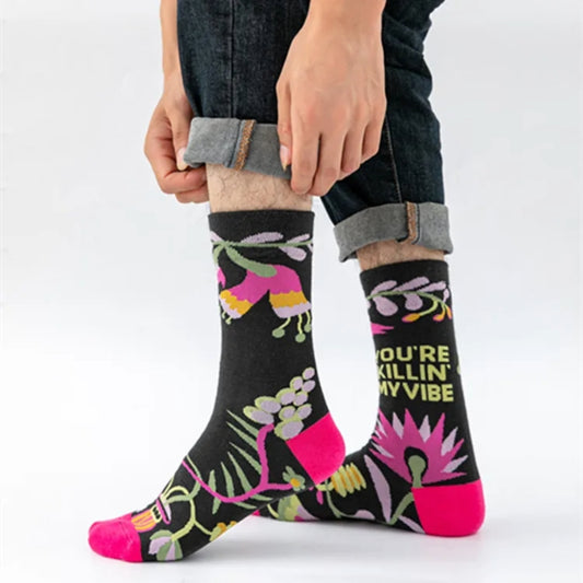 Person wearing black socks with colorful floral patterns and text on a white background