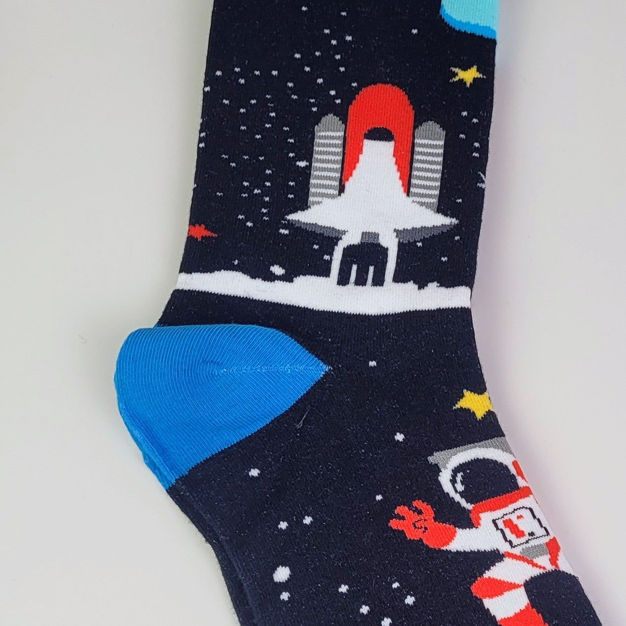 Space-themed sock with astronaut, rocket, and space station design on a white background