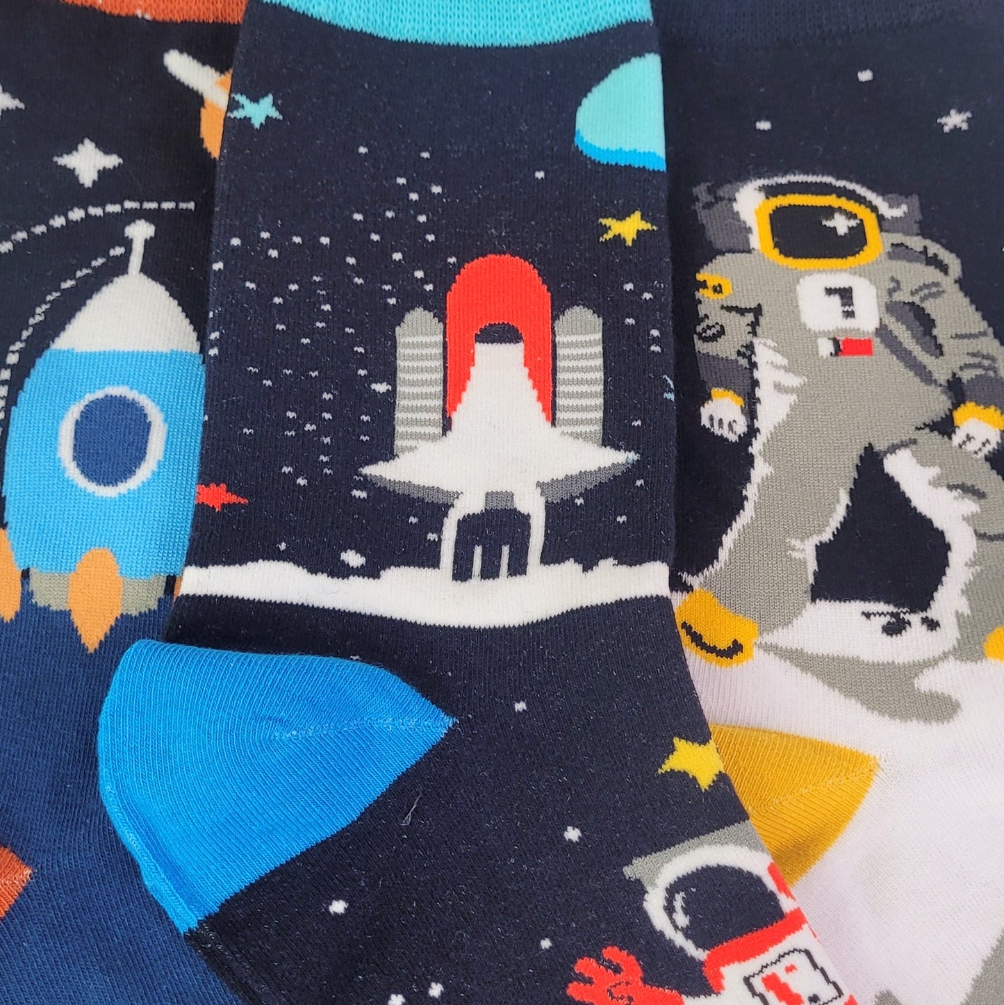 Pair of socks with space-themed design featuring rockets and astronauts.
