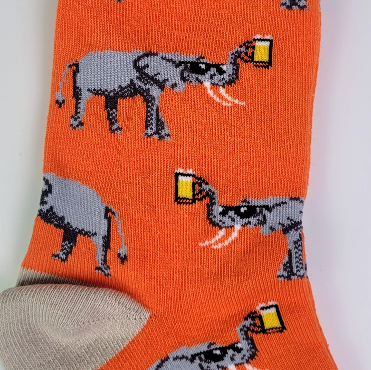 Orange sock with gray elephant and beer design on a white background