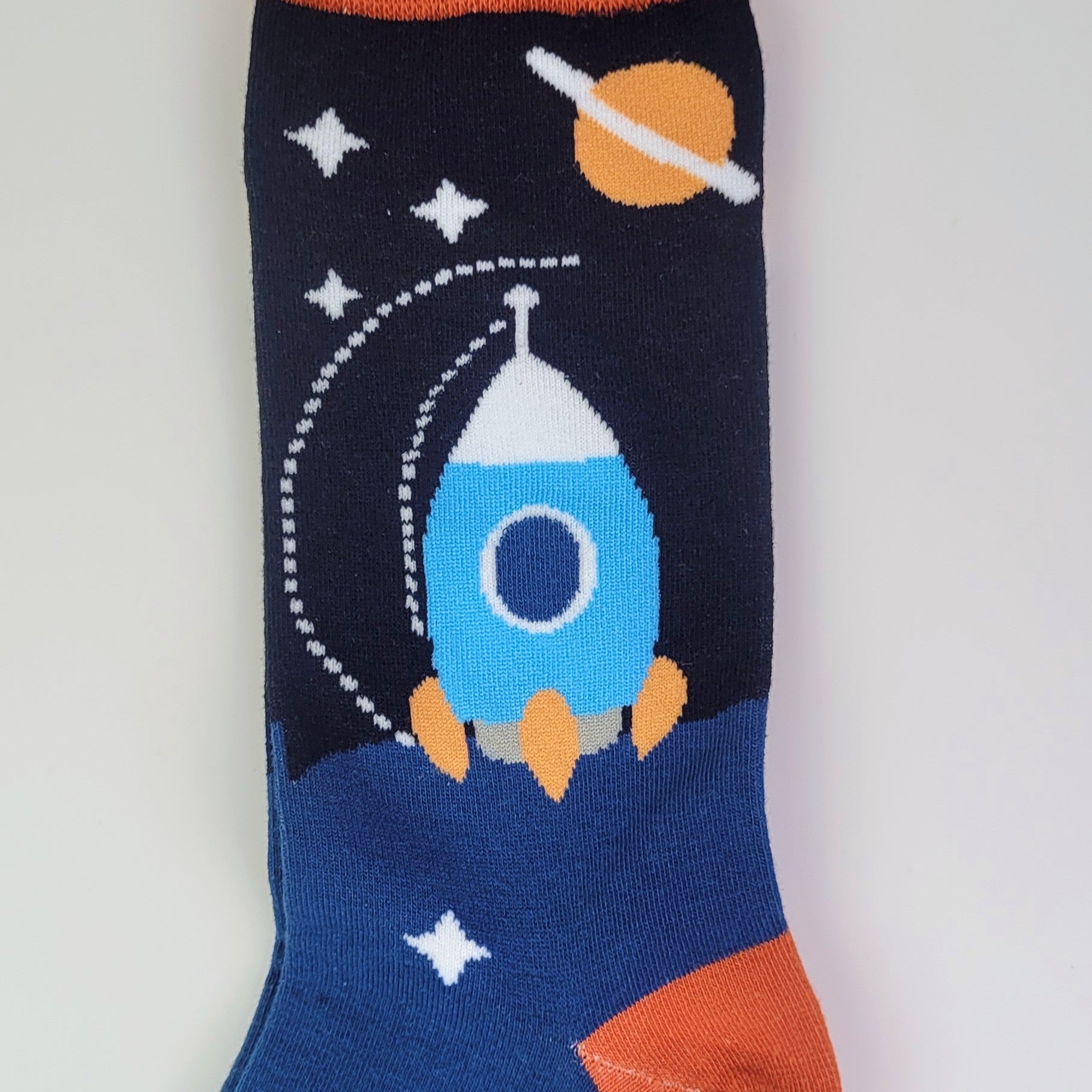 Space-themed sock with rocket design on a plain background