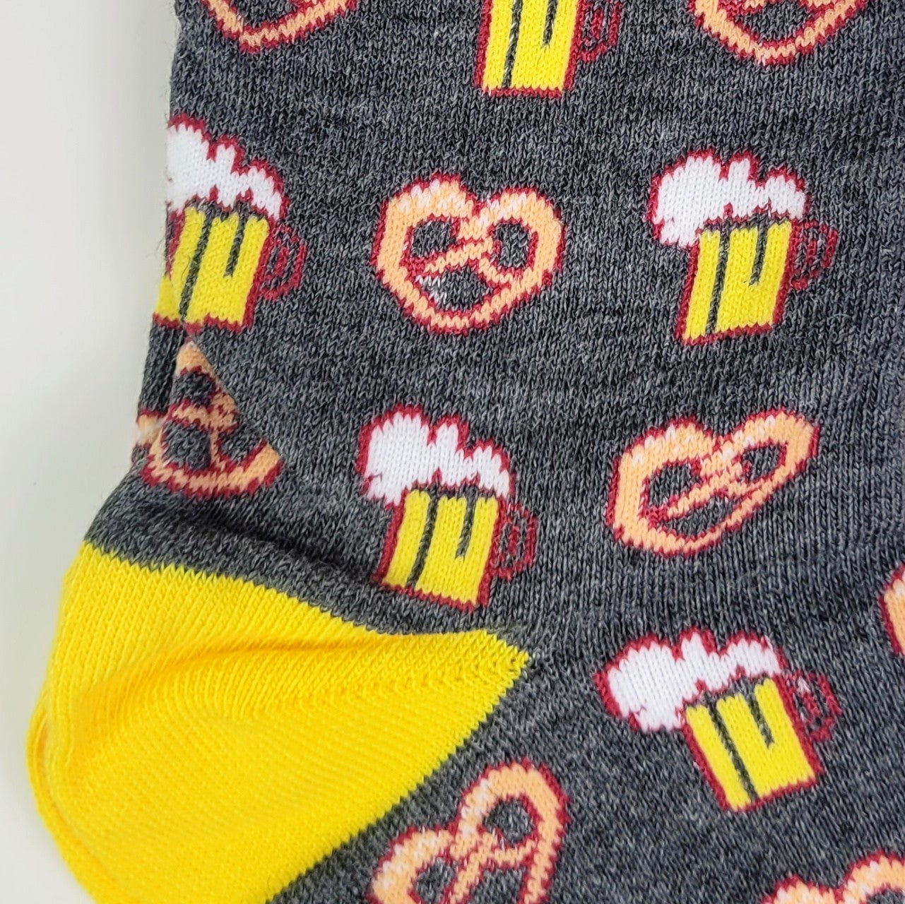 Socks with beer mug and pretzel pattern on a gray background