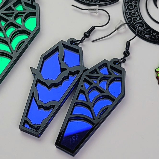 Blue and black spider web earrings on a white background